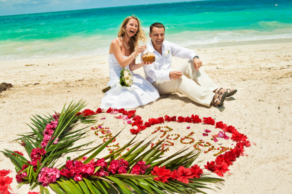Wedding couple in Caribbean beach, happy, laughing and drinking coconut