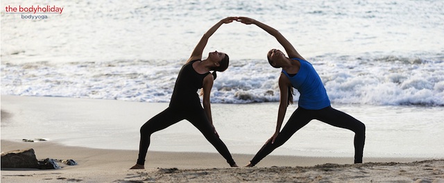 Two women doing yoga on the beach in St. Lucia